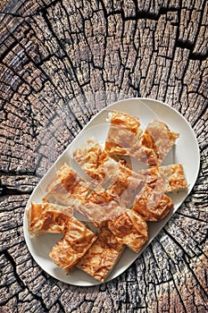 Plateful of Serbian Traditional Gibanica Crumpled Cheese Pie Set on Old Cracked Stump photo