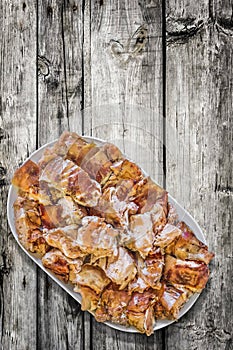 Plateful Of Freshly Spit Roasted Pork Meat Slices Served On Old Weathered Cracked Wooden Garden Table photo