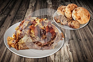 Plateful Of Spit Roasted Pork Ham And Baguette Slices With Pitta Bread Loaves Set On Old Cracked Wooden Garden Table