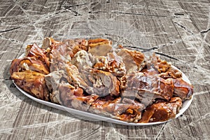 Plateful of Spit Roasted Pork Meat Slices on Old Weathered Cracked Flaky Wooden Picnic Table