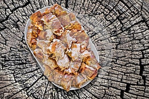 Plateful Of Spit Roasted Pork Meat Slices Set On Old Weathered Cracked Stump Picnic Table photo
