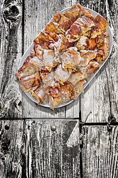 Plateful of Spit Roasted Pork Meat Slices Set on Old Weathered Cracked Wooden Garden Table photo