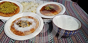 Plates with authentic Arabic dessert on colored tablecloth