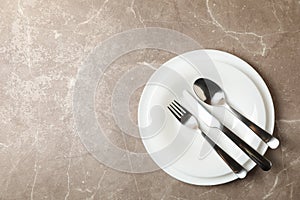 Plates cutlery on gray background, top view