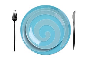 Plates and cutlery on white background, top view