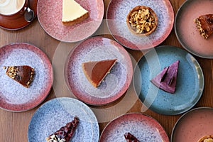 Plates with different cakes on wooden table