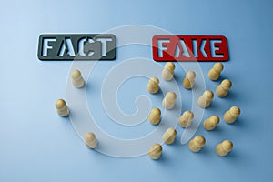 Plates of fact and fake with figures who chose them. Disinformation and propaganda concept.