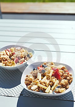 Plates with fresh fruit salad, Granola and berries in the morning on the veranda