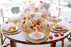 Plates with knotted napkins stand on wicker mats on a festive table