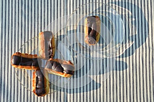 Plates of mini eclairs on checked tablecloth