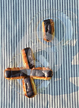 Plates of mini eclairs on checked tablecloth
