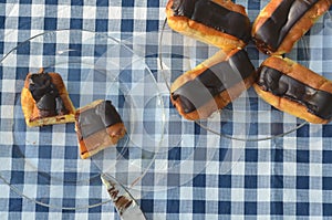 Plates of mini eclairs on checked tablecloth