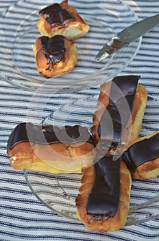 Plates of mini eclairs on checked tablecloth