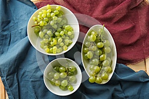 Plates with ripe sweet grapes on table, top view