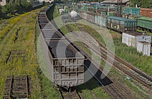 A platform car with coal on the rails