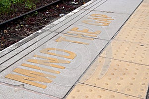 Platform edge at the train station with safety warning