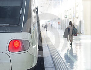 Platform and train, woman with rucksack, reflected in floor