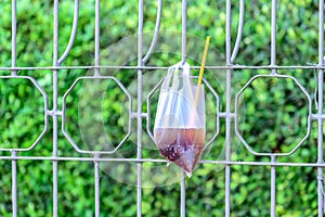 Platic garbage, plastic bag used for sparkling water was left on fence in city