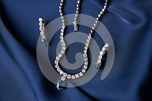 Platinum necklace and earrings with a diamond and blue precious