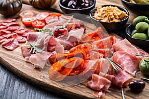 Platter of antipasti with a mixture of salami, prosciutto, bocconcini, peppers, tomatoes and olives