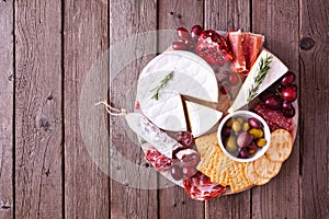 Platter of assorted appetizers, overhead view on a rustic wood background