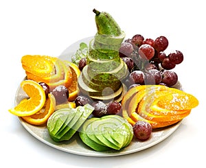 Platter of a assorted fresh fruit cut professionally on a white background