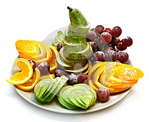 Platter of a assorted fresh fruit cut professionally on a white background photo