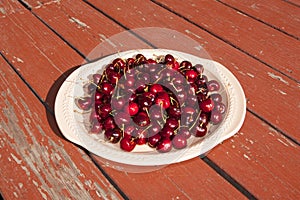 A Platter of Cherries on a Rustic Picnic Table