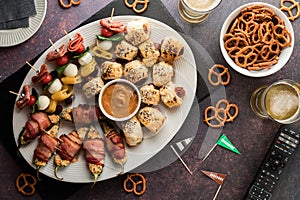 A platter of game day appetizers with beer and pretzels.