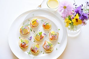platter of mini eggs benedicts as appetizers for a party setting