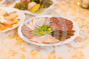 Platter of sliced ham,salami and cured meat with vegetable decoration on festive table