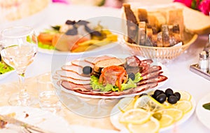 Platter of sliced ham,salami and cured meat with vegetable decoration on festive table