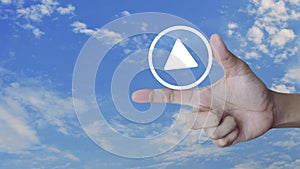 Play button icon on finger over blue sky with white clouds, Business music online concept