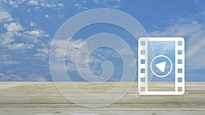 Play button with movie flat icon on wooden table over blue sky with white clouds, Business cinema online concept