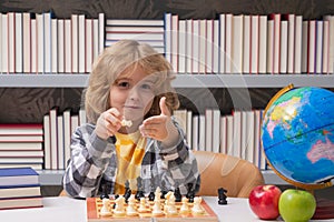 Play chess. Chess for intelligent kid. Child genius, smart pupil playing logic board game. Clever school boy thinking