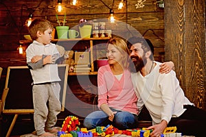 Play concept. Little child with mother and father play with toy bricks. Creative family play. The best place to play