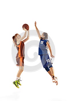 Play defense. Two basketball players, young girls, teen training with basketball ball isolated on white background
