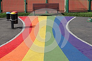 Play ground, rainbow path to a bench in a public garden.