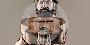 Play the guitar. Guitars and strings. Bearded man playing guitar, holding an acoustic guitar in his hands