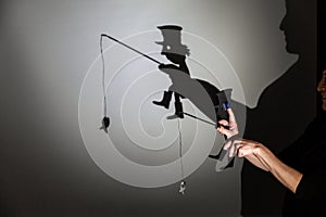 Play shadow projected against a white background. a homeless man with a rod fishing