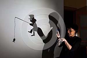 Play shadow projected against a white background. a homeless man with a rod fishing