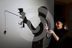 Play shadow projected against a white background. a homeless man with a rod fishing