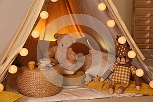 Play tent with toys and pillows indoors, closeup. Modern children`s room interior