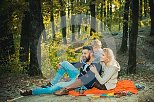 Play together. Mother father and small son play in park. Happy family with kid boy relaxing while hiking in forest