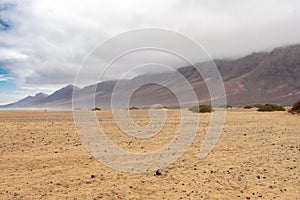 Playa De Cofete Canary Islands, Fuerteventura, Spain. Beach, mountains and Atlantic Ocean against cloudy sky