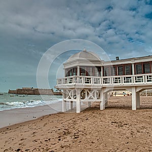 Playa de la Caleta, with its beautiful bathhouse by the sea and the castle of Santa Catalina in the background photo