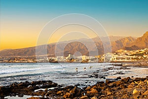 Playa de las Americas. Surfers on the beach in Tenerife at sunset