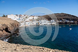 Playa and village El Tufia in Gran Canaria, Spain. White houses located against rocks. scenic view