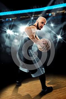 Player in basketball on the floor with ball in hands looking away