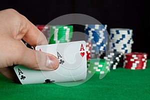 Player checks his hand, two aces in, focus on card